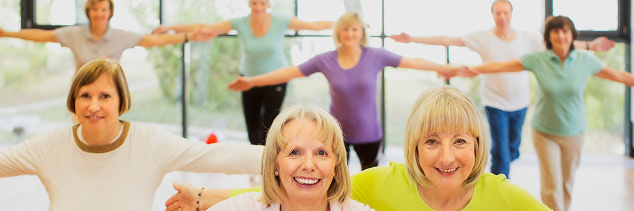 Frauen bei der Gymnastik mit ausgebreiteten Armen