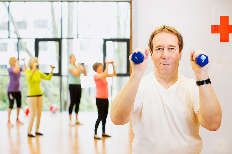 Mann bei der Gymnastik mit Hanteln