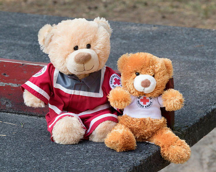 Plüsch-Teddy in Einsatzkleidung mit kleinem Teddy im Arm